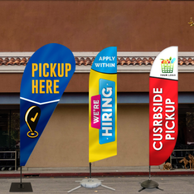Branded feather flags with messages like Pickup Here displayed outdoors.