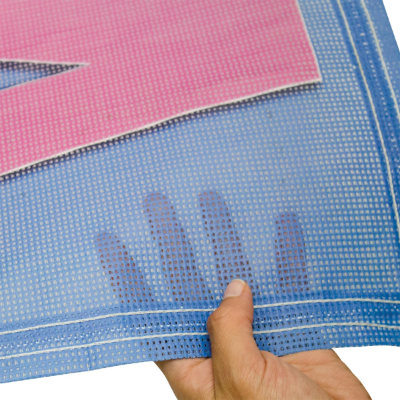 Close-up of hands holding banner material samples including mesh and fabric.